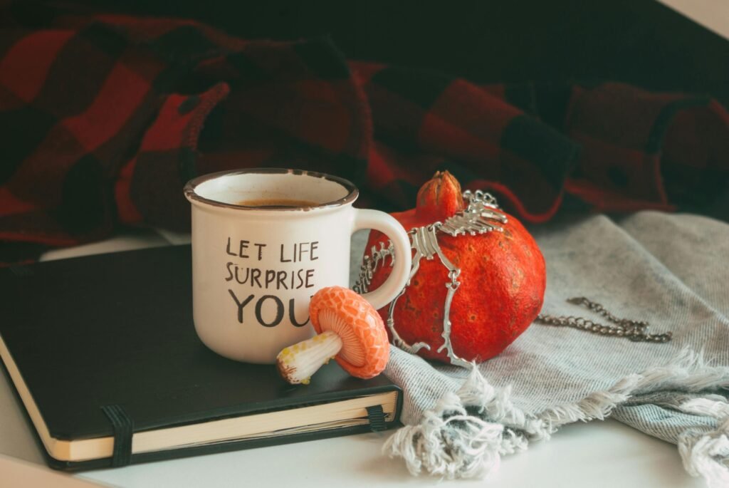 Warm autumn setup with a mug, pumpkin, and notebook creating a cozy atmosphere.
